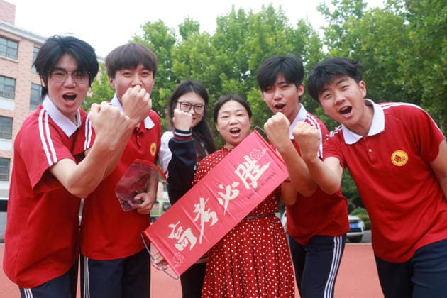 (260607) -- BEIJING, June 7, 2026 -- Students pose for a photo with a teacher outside a national college entrance examination site in Gaomi, east China s Shandong Province, June 7, 2026. This year s national college entrance exam, also known as the gaokao, kicked off Sunday nationwide. (Photo by Xinhua) CHINA-COLLEGE ENTRANCE EXAMINATION (CN) LixHaitao 