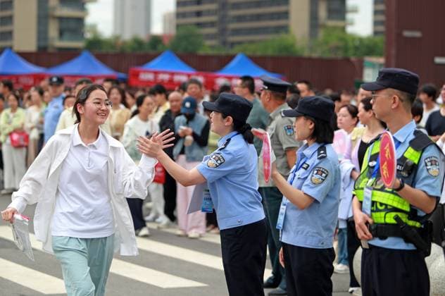 (260607) -- BEIJING, June 7, 2026 -- A police officer claps hands with a student outside a national college entrance examination site in Weinan, northwest China s Shaanxi Province, June 7, 2026. This year s national college entrance exam, also known as the gaokao, kicked off Sunday nationwide. (Photo by Xinhua) CHINA-COLLEGE ENTRANCE EXAM-SERVICE (CN) CuixZhengbo 