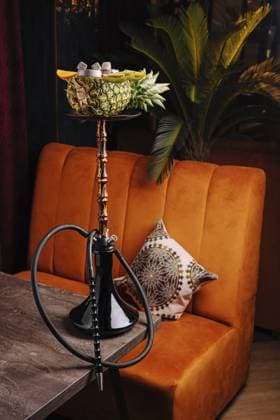 Food, Eine wunderschön arrangierte Wasserpfeife steht auf einem Tisch in einer lebendigen Lounge. Es enthält frische Früchte wie Ananas und Orange und schafft eine warme Atmosphäre zum Entspannen und Genießen Food, A beautifully arranged hookah sits on a table in a vibrant lounge. It features fresh fruits like pineapple and orange, creating a warm atmosphere for relaxation and enjoyment Copyright: imageBROKER AntonxDobrea ibxiqx17836389.jpg
