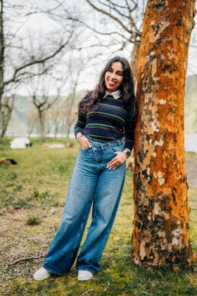 Smiling woman enjoying nature next to tree trunk Ponta Delgada, Azores, Portugal CR_FKNH260603C-2014247-01 ,model released, Symbolfoto