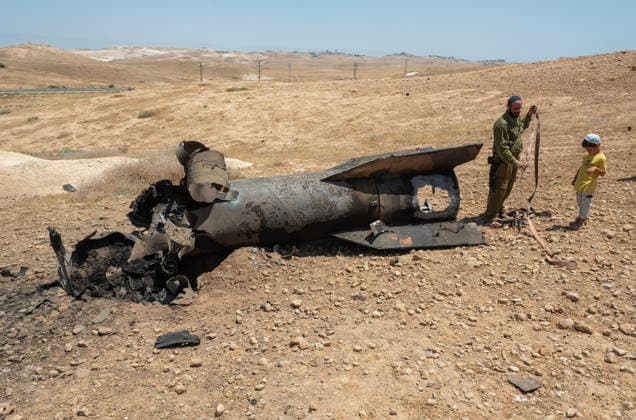 An Israeli solder with his young son as they look at the remains of an Iranian ballistic that was removed from sticking out from the desert landscape in the area near Jericho, in the West Bank on Monday, June 8, 2026 after it was intercepted by Israel and fell to the desert. Iran fired barrages of missiles and Israel carried out military strikes on both Beirut and Iran. Both Iran and Israel have signaled they would wind down the military escalation that shattered the two month ceasefire.  ISR20260608010 JimxHollander