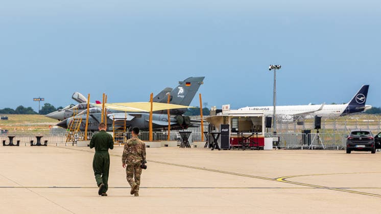 Presserundgang auf der ILA Berlin 2026, Berlin, 09.06.2026 Zwei Soldaten in Uniform gehen auf dem Vorfeld an ausgestellten Militaerjets vorbei. Im Hintergrund ein Panavia Tornado der Bundeswehr mit Sonderbemalung sowie ein Lufthansa-Passagierflugzeug. Schönefeld Selchow Brandenburg Deutschland *** Press tour at the ILA Berlin 2026, Berlin, 09 06 2026 Two soldiers in uniform walk past exhibited military jets on the apron In the background a Panavia Tornado of the Bundeswehr with special livery and a Lufthansa passenger plane Schönefeld Selchow Brandenburg Germany 20260609-1V9A0620-M4000