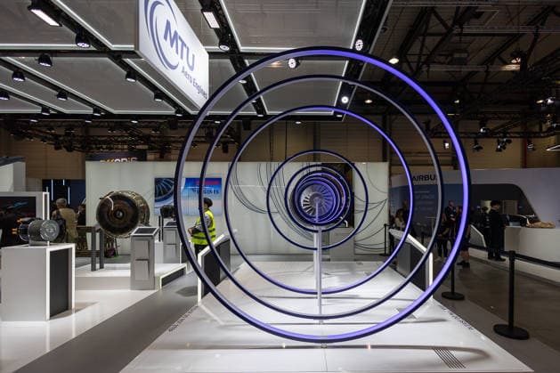 Presserundgang auf der ILA Berlin 2026, Berlin, 09.06.2026 Messestand von MTU Aero Engines mit einer installativen Triebwerksdarstellung aus konzentrischen Ringen und beleuchtetem Fan-Modell. Im Hintergrund sind weitere Triebwerksexponate sowie der Airbus-Stand zu sehen. *** Press tour at ILA Berlin 2026, Berlin, 09 06 2026 MTU Aero Engines stand with an installed engine display of concentric rings and illuminated fan model In the background you can see further engine exhibits and the Airbus stand 20260609-6V2A8358-M4000
