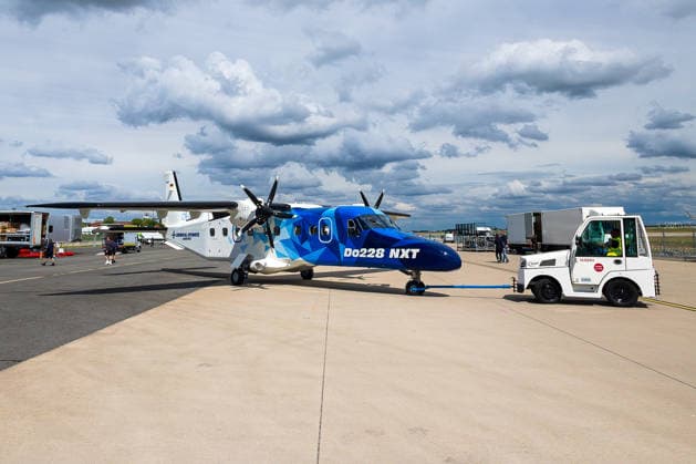 Presserundgang auf der ILA Berlin 2026, Berlin, 09.06.2026 Eine Dornier Do228 NXT von General Atomics Aerotec wird von einem Schleppfahrzeug auf dem Vorfeld bewegt. Das Turboprop-Flugzeug im blauen Grafikdesign ist erstmals auf der ILA Berlin zu sehen. *** Press tour at ILA Berlin 2026, Berlin, 09 06 2026 A Dornier Do228 NXT from General Atomics Aerotec is moved on the apron by a towing vehicle The turboprop aircraft with the blue graphic design can be seen for the first time at ILA Berlin 20260609-6V2A9377-M4000