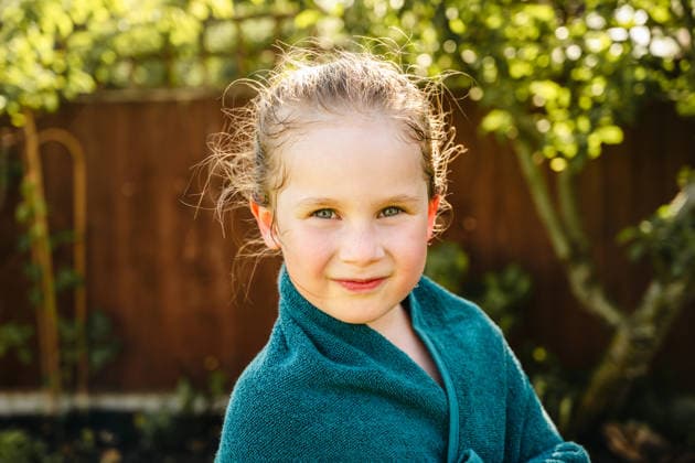 Portrait of wet child wrapped in towel after backyard water play Corby, England, United Kingdom CR_ATMT260528-2039568-01 ,model released, Symbolfoto