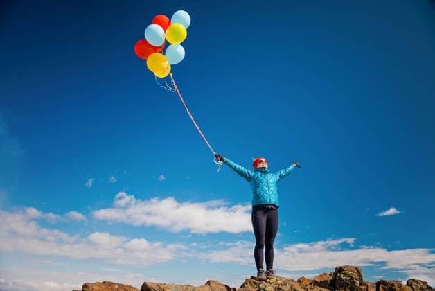 Fit woman celebrates with balloons on mountain summit. Chilliwack, British Columbia, Canada CR_JDIP260608-2046725-01 ,model released, Symbolfoto