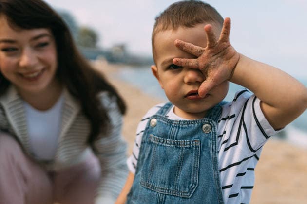Toddler covering face with sandy hand on beach Varna, Varna, Bulgaria CR_PUZV2605283A-2038762-01 ,model released, Symbolfoto