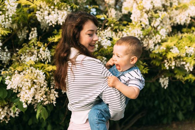Happy mother holding laughing toddler near blooming flowers Varna, Varna, Bulgaria CR_PUZV2605283A-2038770-01 ,model released, Symbolfoto