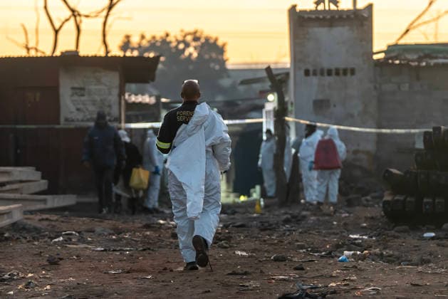 (260610) -- JOHANNESBURG, June 10, 2026 -- People work at the scene of a shooting incident in Cleveland, Johannesburg, South Africa, June 10, 2026. At least 12 people were killed and nine others injured in a mass shooting at an informal settlement in Johannesburg, South Africa s largest city, police said on Wednesday. (Photo by Shiraaz Mohamed Xinhua) SOUTH AFRICA-JOHANNESBURG-SHOOTING INCIDENT ChenxWei 