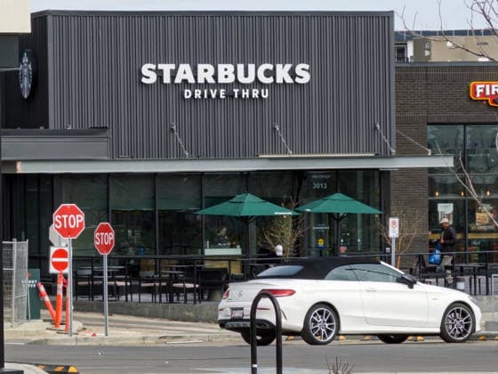 Calgary, Alberta, Kanada. 26. Mai 2026. Außenansicht auf Augenhöhe eines Starbucks-Drive-in, vor dem ein weißes Cabrio geparkt ist. Calgary, Alberta, Canada. May 26, 2026. Exterior eye-level view of a Starbucks drive-thru with a white convertible car parked out front. (License=RM) Copyright: xZoonar.com MarvinxSamuelxTOLENTINO-PINEDAx 25176742