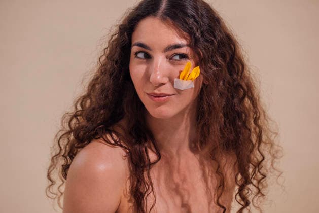 Eine junge Frau mit lockigem Haar, die spielerisch mit gelbem und weißem Papier an der Wange posiert und in einer minimalistischen Umgebung ihren kreativen und künstlerischen Ausdruck zur Geltung bringt Young woman with curly hair is playfully posing with colorful paper on her cheek, highlighting creativity and artistic expression in a minimalistic environment (License=RF) ,model released, Symbolfoto Copyright: xZoonar.com DashaxPetrenkox 25184763 ,model released, Symbolfoto ,property released