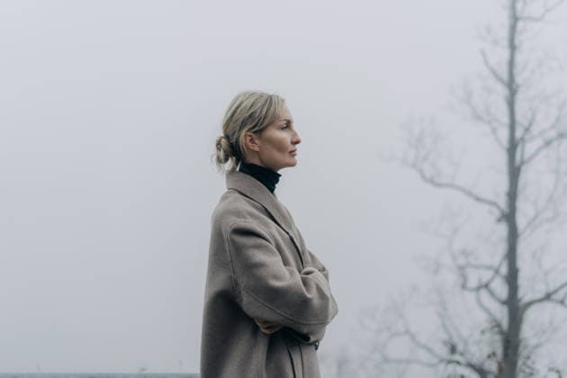 Eine Frau im Mantel auf einer Landstraße bei nebligem Wetter. Eine Atmosphäre der Ruhe in der Umgebung. Woman in a coat on a rural road in foggy weather. Psychological relaxation in the surrounding area. (License=RF) ,model released, Symbolfoto Copyright: xZoonar.com TITOVAxILONAx 25185237 ,model released, Symbolfoto ,property released