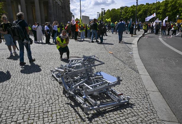 Demonstrators protest healthcare cuts in Berlin by smashing hospital beds BERLIN, GERMANY - JUNE 11: Members of the Berlin Hospital Association and the ver.di trade union take part in the Save the Clinics Now protest in front of the Brandenburg Gate in Berlin, Germany, on June 11, 2026, where an excavator symbolically smashes two hospital beds to protest planned cuts to hospital services. Halil Sagirkaya Anadolu Berlin Germany. Editorial use only. Please get in touch for any other usage.  Copyright: x2026xAnadoluxHalilxSagirkayax