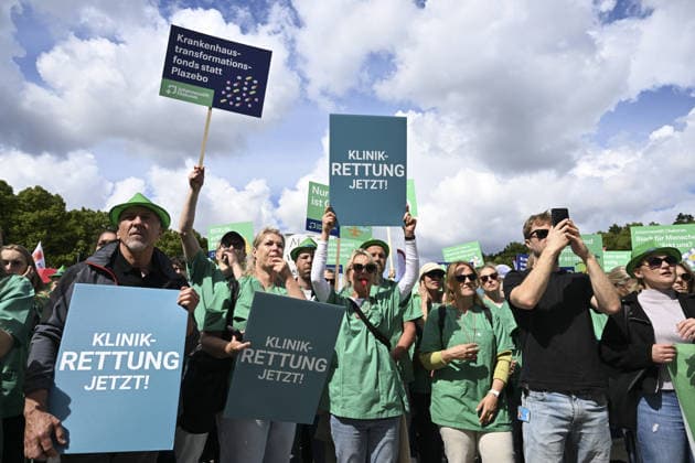 Demonstrators protest healthcare cuts in Berlin by smashing hospital beds BERLIN, GERMANY - JUNE 11: Members of the Berlin Hospital Association and the ver.di trade union take part in the Save the Clinics Now protest in front of the Brandenburg Gate in Berlin, Germany, on June 11, 2026, where an excavator symbolically smashes two hospital beds to protest planned cuts to hospital services. Halil Sagirkaya Anadolu Berlin Germany. Editorial use only. Please get in touch for any other usage.  Copyright: x2026xAnadoluxHalilxSagirkayax