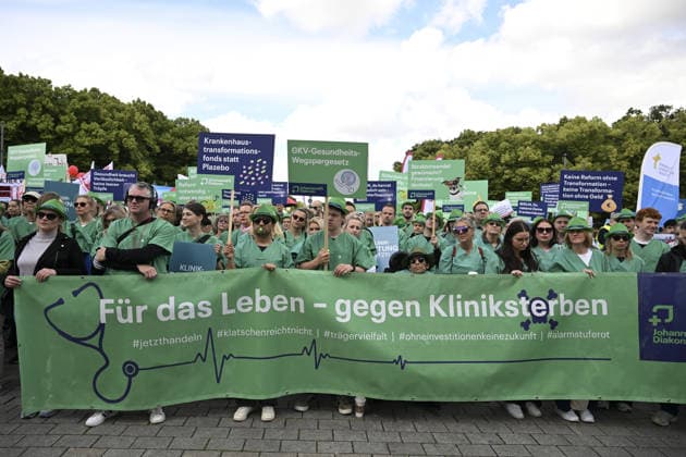 Demonstrators protest healthcare cuts in Berlin by smashing hospital beds BERLIN, GERMANY - JUNE 11: Members of the Berlin Hospital Association and the ver.di trade union take part in the Save the Clinics Now protest in front of the Brandenburg Gate in Berlin, Germany, on June 11, 2026, where an excavator symbolically smashes two hospital beds to protest planned cuts to hospital services. Halil Sagirkaya Anadolu Berlin Germany. Editorial use only. Please get in touch for any other usage.  Copyright: x2026xAnadoluxHalilxSagirkayax