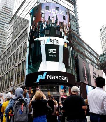 Spectators watch the screens in Times Square showing visuals of Elon Musk and SpaceX branding at the Nasdaq MarketSite Exchange in Times Square on Friday, June 12, 2026 in New York City. Elon Musk celebrated the Nasdaq opening bell Friday as SpaceX prepared to start trading publicly and possibly cementing his status as a trillionaire.  NYP20260612209 JOHNxANGELILLO