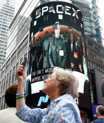 Spectators watch the screens in Times Square showing visuals of Elon Musk and SpaceX branding at the Nasdaq MarketSite Exchange in Times Square on Friday, June 12, 2026 in New York City. Elon Musk celebrated the Nasdaq opening bell Friday as SpaceX prepared to start trading publicly and possibly cementing his status as a trillionaire.  NYP20260612210 JOHNxANGELILLO