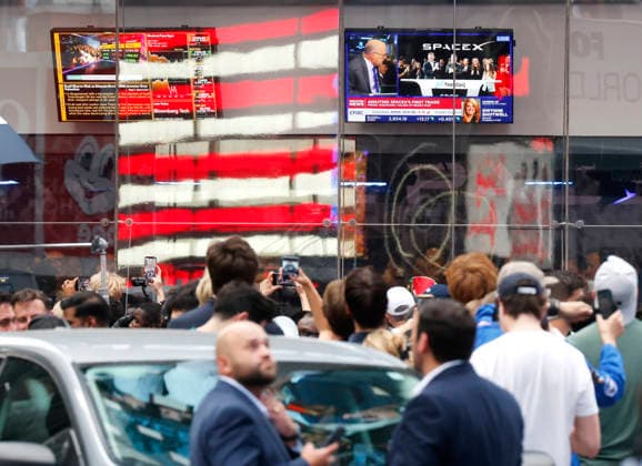 Spectators watch the screens in Times Square showing visuals of Elon Musk and SpaceX branding at the Nasdaq MarketSite Exchange in Times Square on Friday, June 12, 2026 in New York City. Elon Musk celebrated the Nasdaq opening bell Friday as SpaceX prepared to start trading publicly and possibly cementing his status as a trillionaire.  NYP20260612212 JOHNxANGELILLO