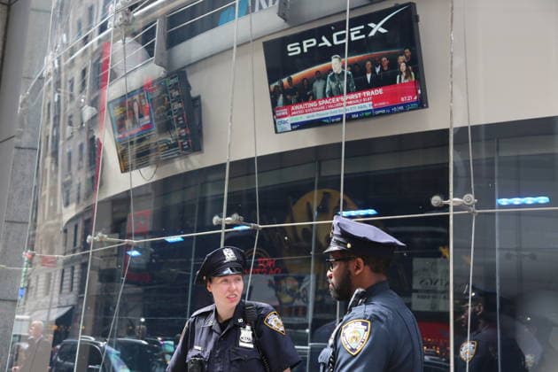 (260612) -- NEW YORK, June 12, 2026 -- New York City police officers stand guard outside the Nasdaq building in Times Square in New York City, the United States, June 12, 2026. Space Exploration Technologies Corp., known as SpaceX, has priced its initial public offering (IPO) at 135 U.S. dollars per share and raised 75 billion dollars through the sale of about 555.56 million shares, U.S. media reported Thursday. The IPO values the company at about 1.77 trillion dollars, according to reports. In terms of fundraising size, the IPO would set a record for an initial public offering. Based on the valuation, SpaceX would rank among the top 10 most valuable U.S.-listed companies. ) U.S.-NEW YORK-SPACEX-IPO LiuxYanan 