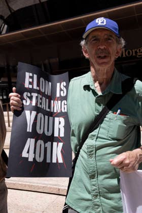June 12, 2026, New York, New York, USA: A coalition of organizations rally outside JP Morgan Chase headquarters in Midtown Manhattan to disrupt Chase CEO J. Dimon s party celebrating E. Musk s launch of SpaceX s IPO on the Nasdaq Stock Exchange and Musk s net worth as a trillionaire. A protester holds a sign that reads ELON IS STEALING YOUR 401K. Organizers denounce working people having SpaceX forced into their 401ks and pensions and the emergence of trillionaire-level wealth in the United States while millions of people face housing insecurity, medical debt, and low wages. New York USA  - ZUMAr174 20260612_znp_r174_014 Copyright: xGinaxMxRandazzox