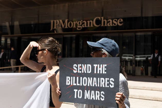 June 12, 2026, New York, New York, USA: A coalition of organizations rally outside JP Morgan Chase headquarters in Midtown Manhattan to disrupt Chase CEO J. Dimon s party celebrating E. Musk s launch of SpaceX s IPO on the Nasdaq Stock Exchange and Musk s net worth as a trillionaire. A protester holds a sign that reads SEND THE BILLIONAIRES TO MARS. Organizers denounce working people having SpaceX forced into their 401ks and pensions and the emergence of trillionaire-level wealth in the United States while millions of people face housing insecurity, medical debt, and low wages. New York USA - ZUMAr174 20260612_znp_r174_011 Copyright: xGinaxMxRandazzox