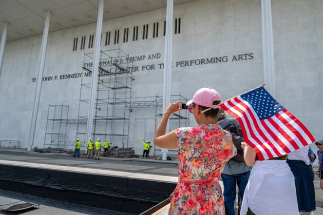 June 12, 2026, Washington, Disitrict Of Columbia, United States: A woman with an American Flag continue erecting scaffolding outside the John F. Kennedy Center for the Performing Arts in Washington, D.C., ahead of the planned removal of President Donald Trump s name from exterior signage. Washington United States  - ZUMAk206 20260612_znp_k206_010 Copyright: xMattxKaminskyx