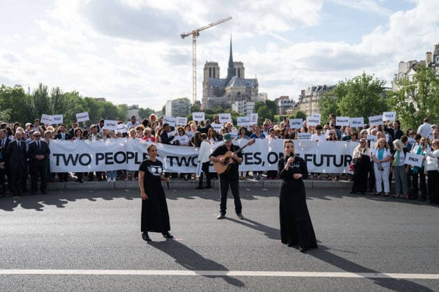 Press conference during the Paris Call for the Two-State Solution - Paris Participants of the Paris Call for the Two-State Solution with Israeli and Palestinian civil society groups carry placards on the Pont de La Tournelle birdge with the Notre-Dame de Paris Cathedral in the background in Paris, France on June 12, 2026. France is hosting this international meeting, attended by ministers from Brazil, Canada, the United Arab Emirates and Turkey, as well as the EU s High Representative for Foreign Affairs, following its recognition of the State of Palestine in 2025. French Foreign Minister reiterated Paris support for the two-state solution, stating that this year could be decisive at the close of the conference. Photo by Gregoire Campion  Copyright: xCampionexGregoire Pool ABACAx