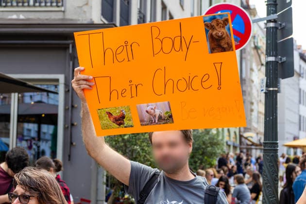 Augsburg, Bavaria, Germany June 13, 2026: Christopher Street Day (CSD) in Augsburg. The parade through the city center promotes the rights of LGBTQ+ people as well as social diversity and tolerance. One participant promotes veganism with a poster; he holds a poster featuring photos of animals with the caption: THEIR BODY THEIR CHOICE *** Christopher Street Day (CSD) in Augsburg. Der Demonstrationszug durch die Innenstadt wirbt für die Rechte von LGBTQ+-Menschen sowie für gesellschaftliche Vielfalt und Toleranz. Ein Teilnehmer wirbt mit einem Plakat für Veganismus, er hält ein Plakat mit Fotos von Tieren mit der Aufschrift: THEIR BODY THEIR CHOICE