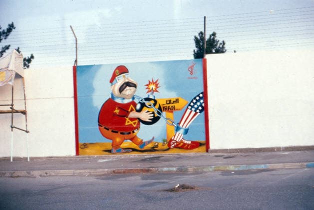 Ein Karikatur-Graffiti von Saddam Hussein befindet sich auf einer Mauer in Teheran. Er trägt ein rotes Hemd mit einem Davidstern, hält eine Bombe und ist an ein Bein mit US-Flaggen-Muster und Hakenkreuz-Schuh gekettet. Iran, 1981 Teheran Iran *** a Caricature Graffiti from Saddam Hussein located at itself at a Wall in Tehran he carries a Red Shirt with a Star of David, holds a Bomb and is to a Leg with US Flags Samples and Swastika Shoe gekettet Iran, 1981 Tehran Iran Copyright: xUnitedxArchivesx xSvenxSimonxArchives SVS_94010005066