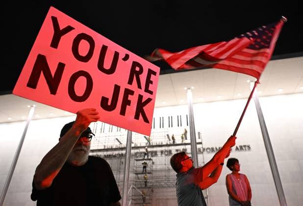 (260614) -- BEIJING, June 14, 2026 -- A man holds a placard as construction crews put up scaffolding in Washington, D.C., the United States, in the small hours of June 13, 2026. A U.S. federal appeals court on Friday denied the Justice Department s last-minute request for a temporary pause of a court order directing that President Donald Trump s name be removed from the John F. Kennedy Center for the Performing Arts. ) XINHUA PHOTOS OF THE DAY LixRui 