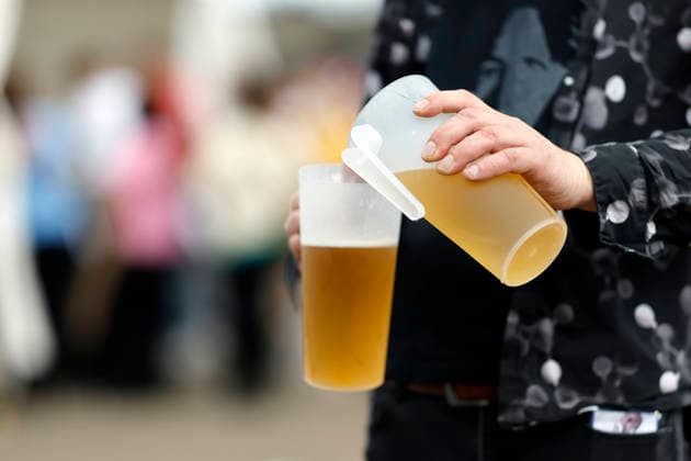 A guest tips beer from one deposit cup into another at the Inselfieber festival in the outdoor area of the Rudolf Weber Arena in Oberhausen on Oberhausen, 13 06 2026 NRW Germany Copyright: xChristophxHardtx