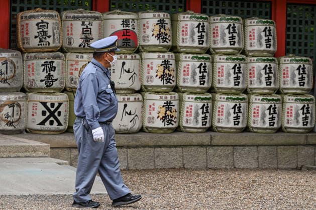 Osaka Keeps Centuries Old Otaue Rice Festival alive OSAKA, JAPAN - JUNE 14: A security guard patrols past rows of traditional decorative sake barrels (kazaridaru) donated by local breweries, during the historic Otaue Rice Planting Festival (Otaue Shinji) at Sumiyoshi Taisha Shrine in southern Osaka, Japan, on June 14, 2026. The ancient agricultural ritual, officially designated as an Important Intangible Folk Cultural Property of Japan, sees the shrine grounds highly secured as thousands of spectators gather to witness ceremonial processions, samurai dances, and sacred rice planting performances. Artur Widak Anadolu Agency Anadolu Osaka Japan. Editorial use only. Please get in touch for any other usage.  Copyright: x2026xAnadoluxArturxWidak AnadoluxAgencyx