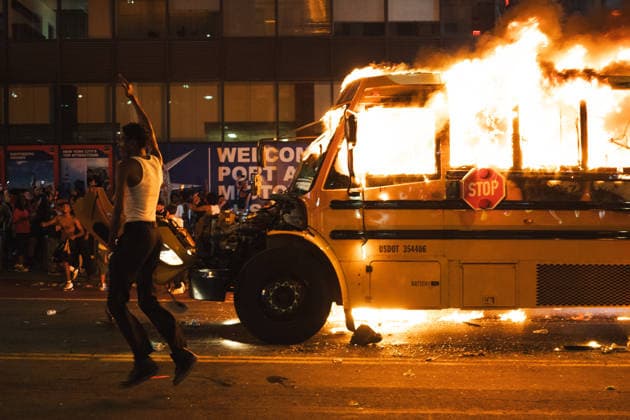 June 14, 2026, New York, New York, USA: A man with a white shirt on jumps in the air with his hand raised as he runs past a yellow school bus that was lit ablaze during the celebration of the New York Knicks winning the NBA Finals. New York USA - ZUMAf193 20260614_znp_f193_002 Copyright: xDerekxFrenchx