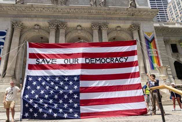 June 14, 2026, New York, New York, USA: Demonstrators join Rise and Resist s We Are In A State Of Emergency Flag Day anti-Trump protest on the steps of the New York Public Library (NYPL) branch on Fifth Avenue in Midtown Manhattan where a giant upside down flag is hoisted reading SAVE OUR DEMOCRACY. New York USA  - ZUMAr174 20260614_znp_r174_005 Copyright: xGinaxMxRandazzox