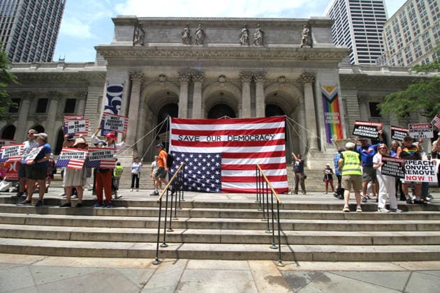 June 14, 2026, Manhattan, New York, USA: New York, New York June 14,.2026... The group Rise and Resist today protested President Trump by flying a 12 x 18 foot Ã¢â‚¬oedistressedÃ¢â‚¬Â American flag in front of a place free of Trump & Republicans, the steps of the New York Public Library. Manhattan USA  - ZUMAct2_ 20260614_faf_ct2_052 Copyright: xBrucexCotlerx