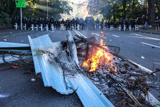 June 14, 2026, Geneva, Switzerland, European Union: A fire burns from debris and other materials as a cordon of police officers stands in the background during protests in Geneva ahead of the G7 summit, which begins tomorrow in Evian-les-Bains. Geneva European Union  - ZUMAo116 20260614_znp_o116_019 Copyright: xBiancaxOterox