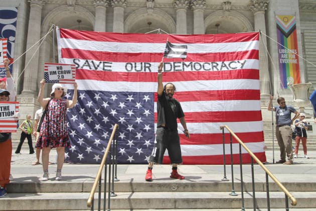 June 14, 2026, Manhattan, New York, USA: New York, New York June 14,.2026... The group Rise and Resist today protested President Trump by flying a 12 x 18 foot Ã¢â‚¬oedistressedÃ¢â‚¬Â American flag in front of a place free of Trump & Republicans, the steps of the New York Public Library. Manhattan USA - ZUMAct2_ 20260614_faf_ct2_047 Copyright: xBrucexCotlerx