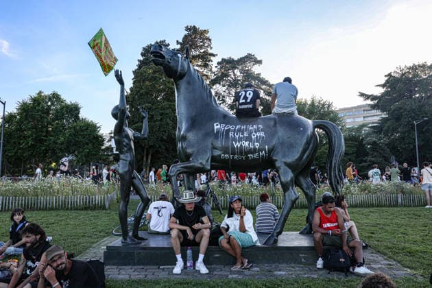 June 14, 2026, Geneva, Switzerland, European Union: Protesters gather around a public statue in Geneva ahead of the G7 summit, with graffiti reading Ã¢â‚¬oePedophiles Rule Our World Destroy ThemÃ¢â‚¬Â written on the horse sculpture. Geneva European Union - ZUMAo116 20260614_znp_o116_017 Copyright: xBiancaxOterox