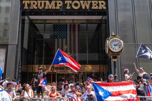 June 14, 2026, New York, New York, USA: A man waves a giant Puerto Rican flag in front of Trump Tower as the 69th Puerto Rican Day Parade makes its way up Fifth avenue. New York USA - ZUMAp288 20260614_znp_p288_019 Copyright: xSyndixPilarx
