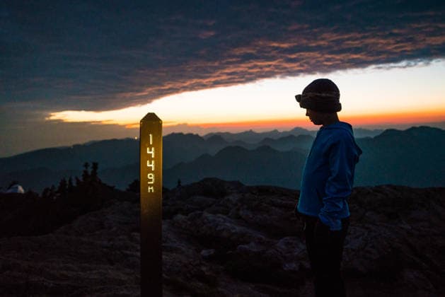 Young hiker stands on a mountain peak at dawn Vancouver, British Columbia, Canada CR_JDIP260614C-2050848-01 ,model released, Symbolfoto