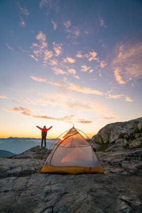Person celebrates sunrise at mountain campsite Vancouver, British Columbia, Canada CR_JDIP260614C-2050857-01 ,model released, Symbolfoto
