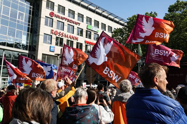 Teilnehmer der Kundgebung mit Fahnen vom BSW - BSW Kundgebung in Magdeburg (Sachsen-Anhalt) auf dem Willy Brandt Platz am Hauptbahnhof unter dem Motto, WM 2026 - Weg mit Merz! *** Participants in the rally with flags from the BSW BSW rally in Magdeburg Saxony-Anhalt on Willy Brandt Platz at the main railway station under the motto, World Cup 2026 Away with Merz