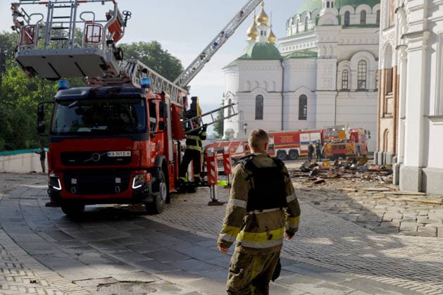 A firefighter stands in front of firefighting vehicles behind the Dormition Cathedral at the Kyiv Pechersk Lavra, where the roof caught fire during a massive Russian combined attack, Kyiv, Ukraine, June 15, 2026. The Russian army launched a large-scale assault on the Ukrainian capital with missiles and strike drones, killing four people and injuring 28, including children and a pregnant woman. At least 140,000 consumers were left without electricity due to damage to power grids. Residential buildings, the Kyiv Pechersk Lavra, the Mystetskyi Arsenal Museum Complex, the Dovzhenko Film Studio, and the building of the High Anti-Corruption Court sustained damage. (Photo by Marianna Kotyk Ukrinform) Massive Russian attack damages Kyiv Pechersk La  Copyright: xMariannaxKotykx