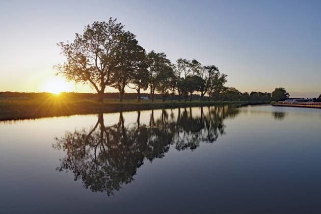 Creative Highlights World #2 Sonnenuntergang über einer Reihe von Bäumen, die sich im Wasser spiegeln, Hajstorp, Götakanal, Västra Götalands län, Schweden Sunset over a series of trees reflecting in water, Hajstorp, Göta Canal, Västra Götalands län, Sweden Copyright: imageBROKER ReinhardxPantke ibxrpa18043218.jpg