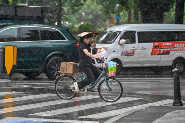GUANGZHOU, CHINA - JUNE 15: A resident rides in the rain on June 15, 2026 in Guangzhou, Guangdong Province of China. Multiple districts in Guangzhou on June 15 issued orange alert for rainstorms due to continuous influence of strong thunderstorm clouds.  Copyright: xChinaxNewsxServicex 111648333531