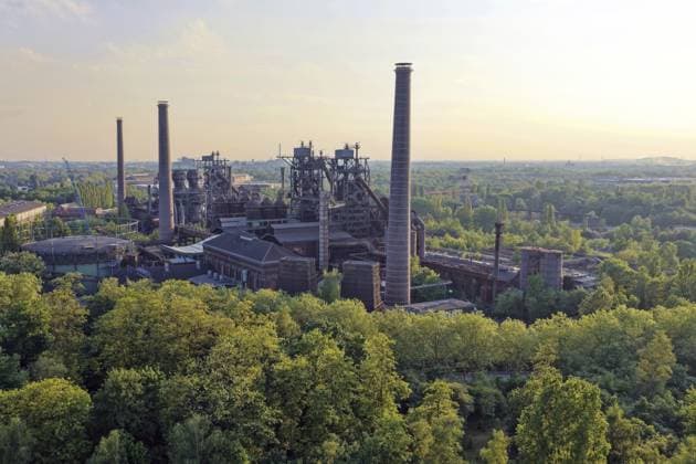 Die Panoramaaufnahme zeigt das monumentale Industriedenkmal des ehemaligen Hüttenwerks in der Abendsonne. Mächtige Schornsteine, Hochöfen und Industriegebäude ragen aus einem Meer von grünen Bäumen empor und verdeutlichen den Wandel von der Schwerindustrie zur grünen Oase. Das warme Licht verleiht der historischen Kulisse im Ruhrgebiet eine ganz besondere, friedliche Atmosphäre. Duisburg, Duisburg, Düsseldorf, Nordrhein-Westfalen, Deutschland The panoramic photo shows the monumental industrial monument of the former metallurgical plant in the evening sun. Huge chimneys, blast furnaces and industrial buildings rise up from a sea of green trees and illustrate the transformation from heavy industry to a green oasis. The warm light gives th Copyright: imageBROKER fotoping ibxwth18064573.jpg