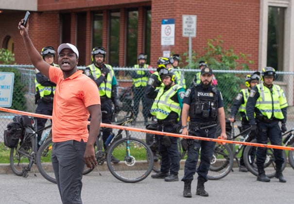 June 15, 2026, Montreal, Pq, Canada: A protester rallies others outside Montreal police station 39 in Montreal North during an anti police brutality protest on Monday June 15, 2026. Montreal Canada  - ZUMAc35_ 20260615_zaf_c35_140 Copyright: xPeterxMccabex