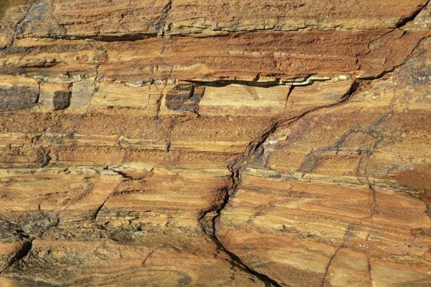 Detailreiches Naturfoto einer rötlich-braunen Sandsteinformation an einer Küste. Die Nahaufnahme zeigt die ausgeprägte Textur horizontaler Sedimentschichten, die durch jahrhundertelange Erosion geformt wurden. Eingebettet in die felsige Struktur sind verschiedene kleinere, bunte Kieselsteine und Gezeitenpools mit klarem Wasser. Das Bild besticht durch warme Erdtöne von Ocker bis Terrakotta und eignet sich perfekt für Hintergründe, Geologie-Themen und abstrakte Naturbilder Detailed nature photo of a reddish-brown sandstone formation on a coast. The close-up shows the distinctive texture of horizontal sediment layers formed by centuries of erosion. Embedded in the rocky structure are various smaller, colorful pebbles and tide pools with c Copyright: imageBROKER fotoping ibxwth18084039.jpg