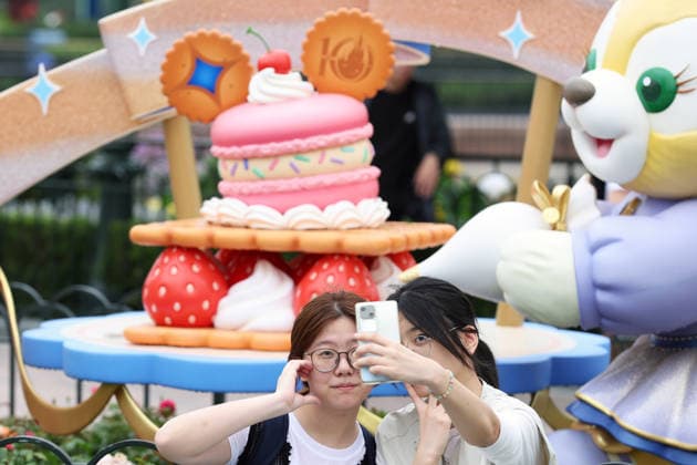 SHANGHAI, CHINA - JUNE 16: Visitors pose for a photo with a 10th birthday cake in front of the Enchanted Storybook Castle at Shanghai Disney Resort on June 16, 2026 in Shanghai, China. The resort has welcomed over 100 million visitors since opening on June 16, 2016.  Copyright: xChinaxNewsxServicex 111648530376