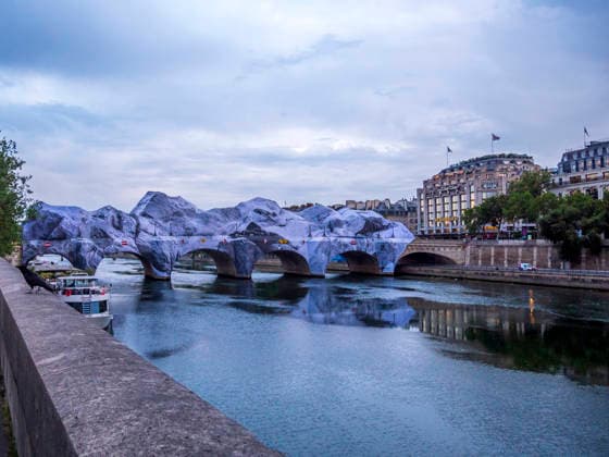 JR’s Caverne du Pont Neuf opened in Paris, France, on June 16, 2026. After several days of uncertainty and intensive repairs, artist JR’s Caverne du Pont Neuf is finally open to the public in Paris. Hit by severe weather in early June, the monumental installation sustained significant damage that delayed its opening by nine days. Teams worked tirelessly to restore this giant, 120-meter-long inflatable structure. For this project, JR chose not to hide the storm’s scars. The repair seams were deliberately highlighted in black, making the work’s scars from the weather visible. Now accessible for free, this urban cave offers an unusual sensory journey. Passersby discover a mineral-like tunnel bathed in an exclusive soundtrack by Thomas Bangalt  Copyright: xThÃ oxCastillonx xBestimagexThÃ oxCastillonx xBestimagex